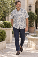 Man wearing the Engraved Hummingbird Garden Resort Shirt in Pearl Gray in a garden courtyard