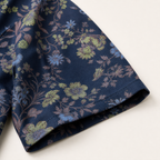Close-up of sleeve edge and folds on navy botanical vine garden shirt